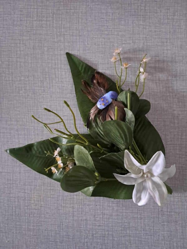 Détail de pince à cheveux fleur composition avec des fleurs des feuille set un oiseau bleu et brun